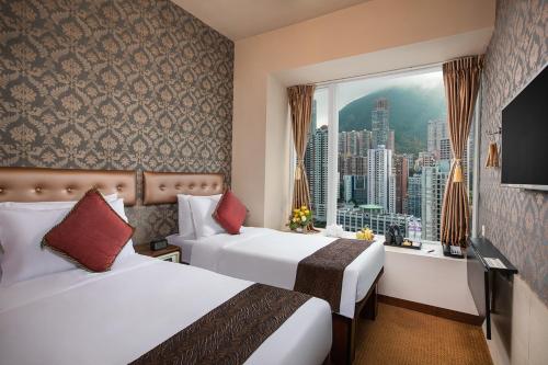 香港华美达海景酒店的酒店客房设有两张床和窗户。