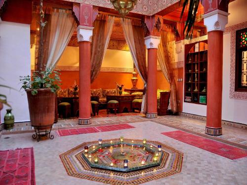 马拉喀什里亚德莉拉庭院旅馆的一间大房间,配有一张桌子,一间大房间,中间设有一个游泳池