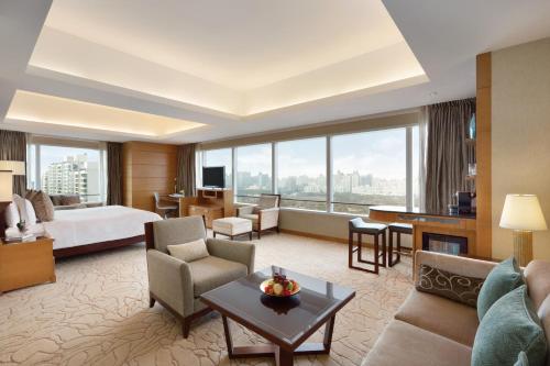 上海上海浦东嘉里大酒店的酒店客房设有床和客厅。