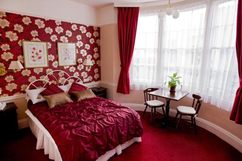 布莱顿霍夫The Market Inn的红色卧室配有床和桌子