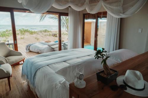 Cabo NhamuaEclectic Beach Retreat的一间卧室配有一张床,享有海滩美景