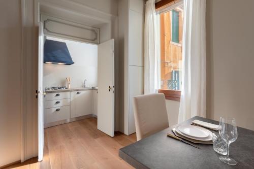 威尼斯Bridge of Sighs Luxurious Apartment的一间带桌子的用餐室和一间厨房