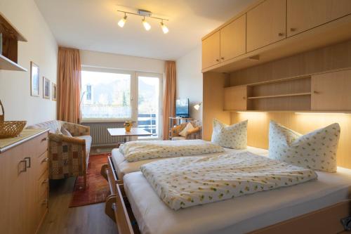 奥伯斯特多夫艾格旅馆的一间带两张床的卧室和一间带窗户的厨房