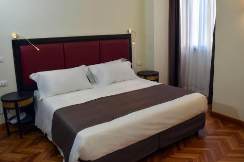 雷焦卡拉布里亚Torrione Hotel的一间卧室配有一张大床和两张桌子
