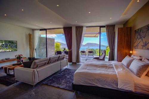 芭东海滩Ocean Rock Kalim的一间卧室设有一张大床和一个大窗户