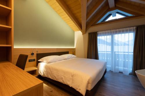 利维尼奥中央酒店的一间卧室设有床、窗户和水槽