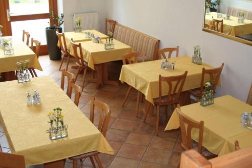 Mühlheim an der DonauHotel Gästehaus Theresia Garni的餐厅设有桌椅和黄色桌布