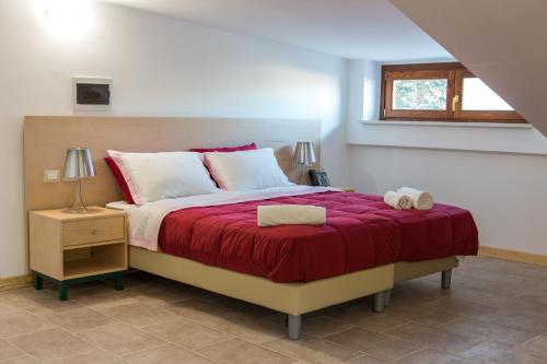 塞拉圣布鲁诺Il Moscardino Country Resort的一间卧室配有一张带红色毯子的大床