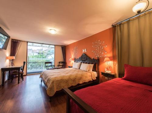 阿雷基帕埃莉莎别墅精品酒店的一间卧室配有一张床、一张书桌和一个窗户。