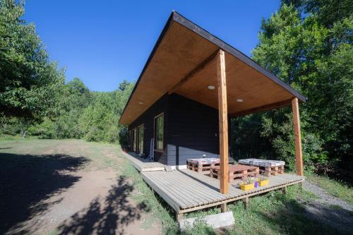 里坎雷Pucura Eco Lodge的小屋设有木门廊和野餐桌