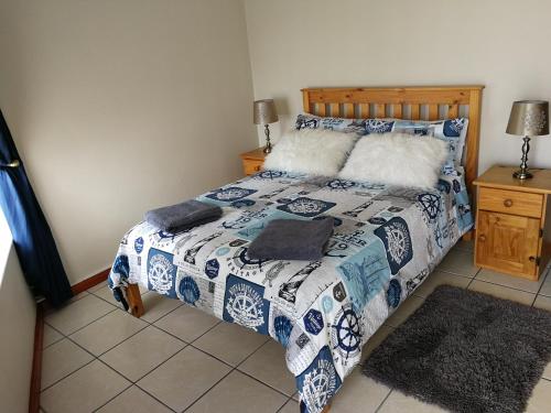 莫塞尔湾The White House Apartment的一间卧室配有一张带蓝色和白色棉被的床