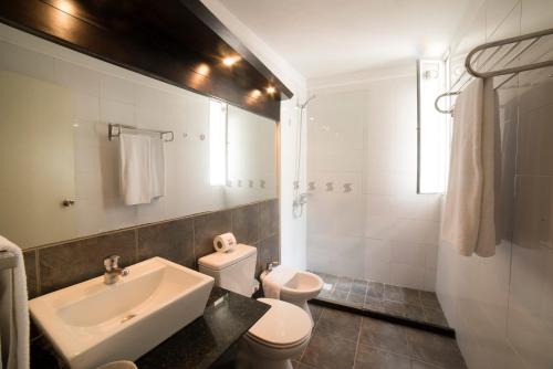 蒙得维的亚27 Suites Hotel的白色的浴室设有水槽和卫生间。