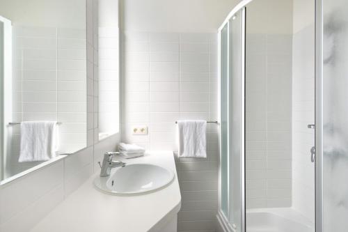 安特卫普安特卫普中心世纪酒店的白色的浴室设有水槽和淋浴。
