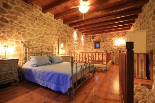 赛罗卡波斯Lithos Traditional Guest Houses的一间卧室设有一张床和石墙