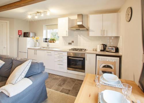 EmleyHost & Stay - Cosy Cottage的厨房以及带沙发和桌子的客厅。