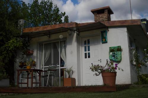 拉斯罗萨斯Cabaña Su Estar的白色的小房子,设有门廊和桌子