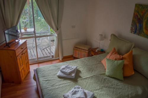 拉斯罗萨斯Cabaña Su Estar的一间卧室设有一张床和一个阳台的窗户。