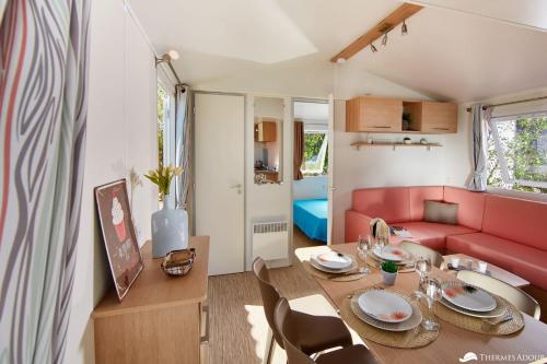 圣保罗莱达Camping des Abesses的客厅配有桌子和红色沙发