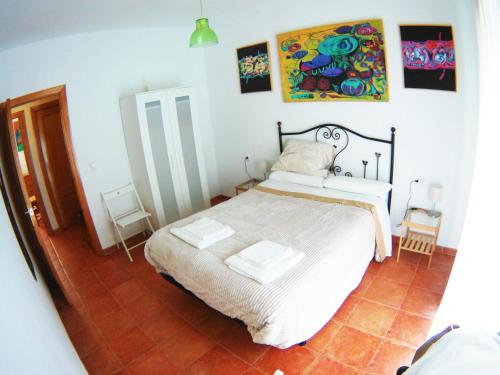 桑蒂蓬塞Casa junto a Itálica的卧室配有一张床,墙上挂有绘画作品