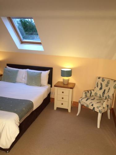 肯梅尔两英里小屋旅舍的卧室配有床、椅子和窗户。