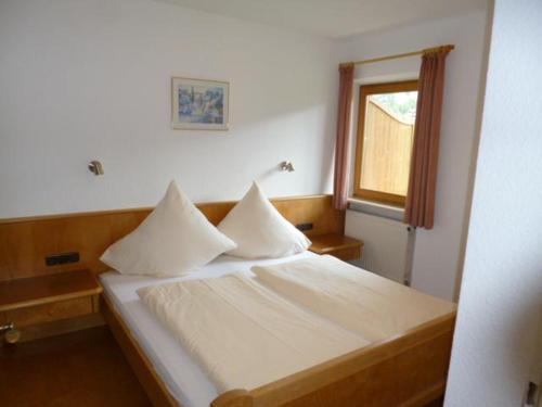奥伯约赫Haus Marianne的一间卧室配有一张带白色床单的床和一扇窗户。