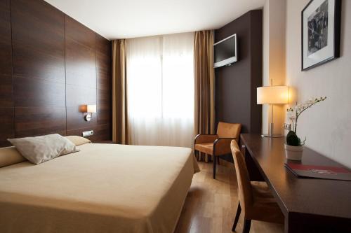 科利亚多·比利亚尔瓦FC尔瓦别墅酒店的配有一张床和一张书桌的酒店客房