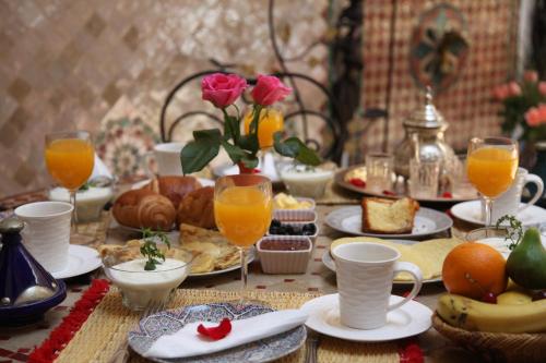 马拉喀什查理玛摩洛哥传统庭院住宅的盛满食物和橙汁及饮料的桌子