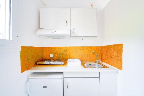 DhavgátaArt Studio Kefalonia的厨房配有白色橱柜和水槽
