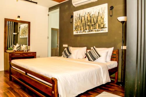科伦坡Eden Studio Apartments - 1的卧室配有一张带白色床单和枕头的大床。