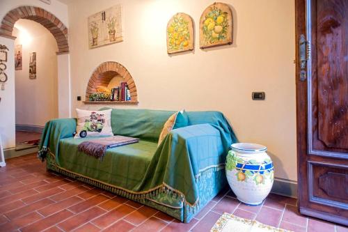帕拉伊阿Appartamenti La Rocca的客厅配有绿色沙发和花瓶