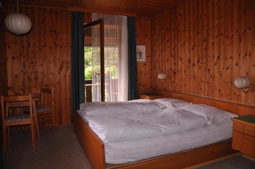 索普拉布扎诺Gasthof Schluff的一间卧室设有一张床、一个窗口和一把椅子