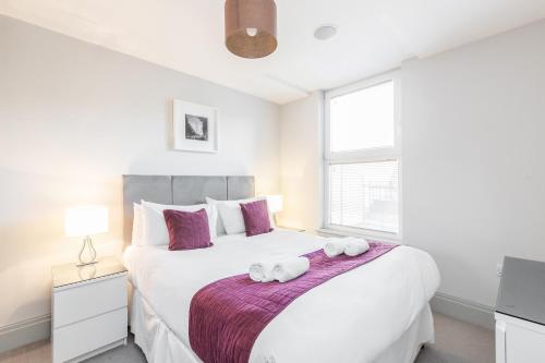 泰晤士河畔里士满Roomspace Serviced Apartments - The Quadrant的卧室配有带毛巾的大型白色床