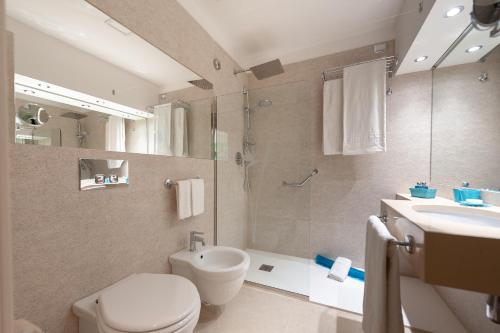 拉古萨码头Acacia Palace的浴室配有卫生间、盥洗盆和淋浴。