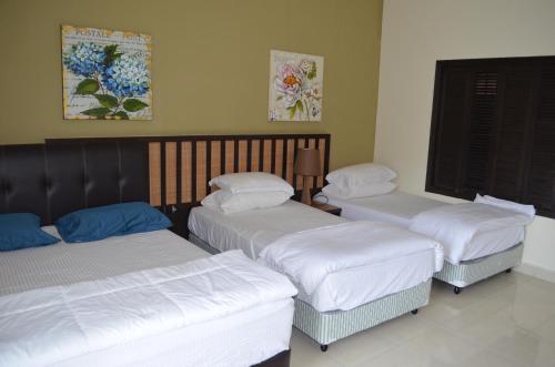 Kampong Tanjong PechahGold Coast Morib Ain Studio的配有白色床单的客房内的三张床