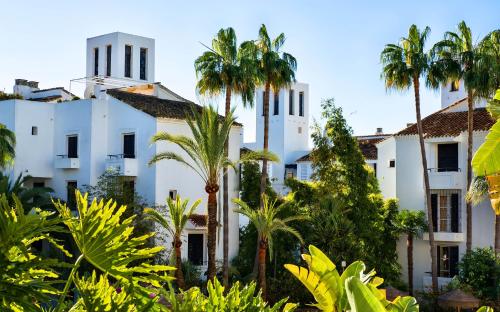 马贝拉马贝拉奥纳阿兰达俱乐部酒店的前方有棕榈树的白色建筑