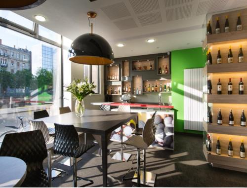 斯特拉斯堡斯特拉斯堡小法国宜必思尚品酒店的一间配备有桌椅的用餐室和绿色的墙壁
