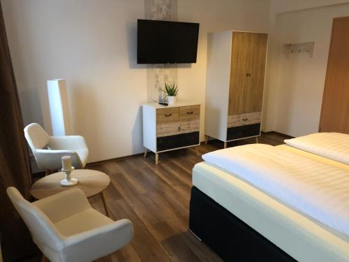 萨勒河畔瑙姆堡祖姆芮伯斯道克伽尼酒店的酒店客房,配有床和电视
