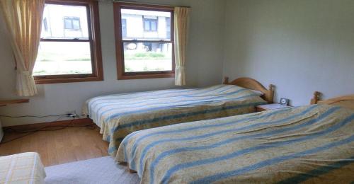 南鱼沼市Pension Come Relaxing Western-style room- Vacation STAY 14977的带2扇窗户的客房内的2张床
