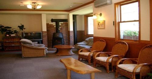南鱼沼市Pension Come Relaxing Western-style room- Vacation STAY 14977的客厅配有椅子和燃木炉