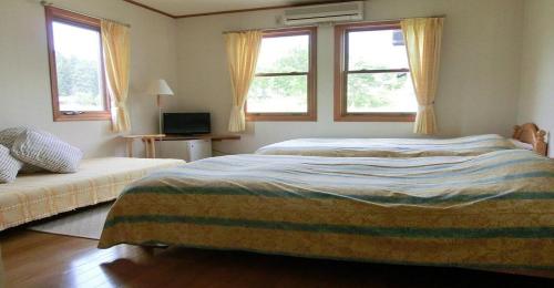 南鱼沼市Pension Come Relaxing Western-style room- Vacation STAY 14977的一间卧室设有两张床和两个窗户。