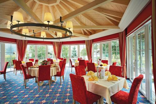纽科琴格罗斯夫胡博图斯酒店的一间带桌椅和吊灯的用餐室
