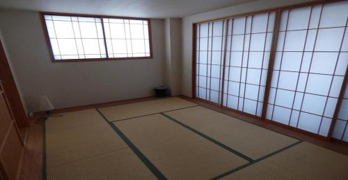 京都Guesthouse Hyakumanben Cross japanese room / Vacation STAY 15396的一间空房间,设有两个窗户和瓷砖地板