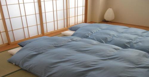 京都Guesthouse Hyakumanben Cross japanese room / Vacation STAY 15396的一间卧室,配有两张大蓝色棉被
