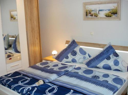 费马恩Ferienhaus Seeschwalbe的一间卧室配有一张带蓝色和白色枕头的床