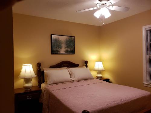 列克星敦Cozy and Spacious-4 Bedrooms Townhouse的一间卧室配有一张带两盏灯的床和吊扇。