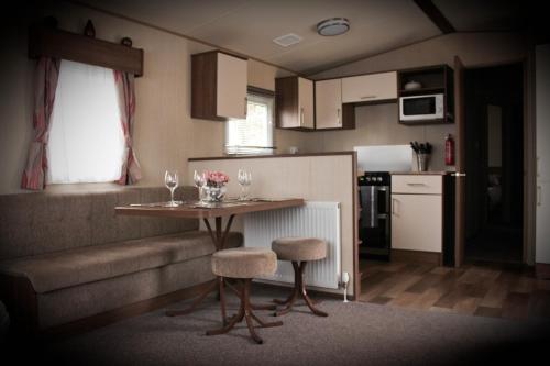 佩恩顿3 Bed Static Caravan @ Hoburne Devon Bay的小厨房配有桌椅