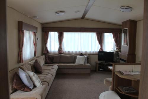 佩恩顿3 Bed Static Caravan @ Hoburne Devon Bay的带沙发和电视的客厅