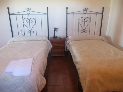 Valencia de las Torres坎波比尔托青年旅馆的两张睡床彼此相邻,位于一个房间里