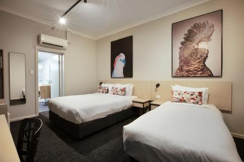 卧龙岗Nightcap at the Charles Hotel的酒店客房设有两张床和窗户。