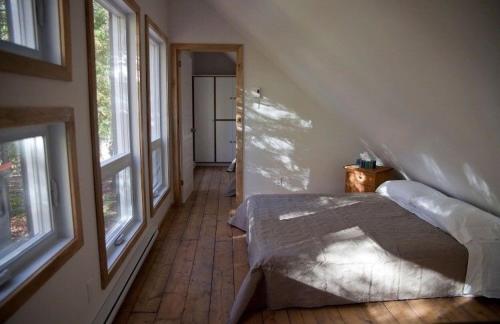 梅戈格Le Cocon Orford Domaine Cheribourg的一间设有床铺的卧室,位于带窗户的房间内